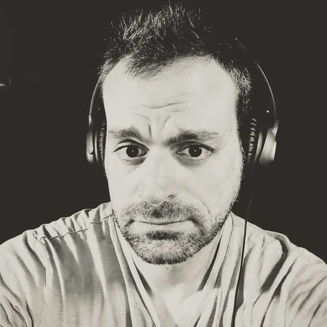 Ken Morico wearing headphones, focused and working